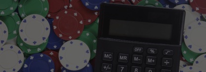 Spread out poker chips with a black digital calculator on top of the chips